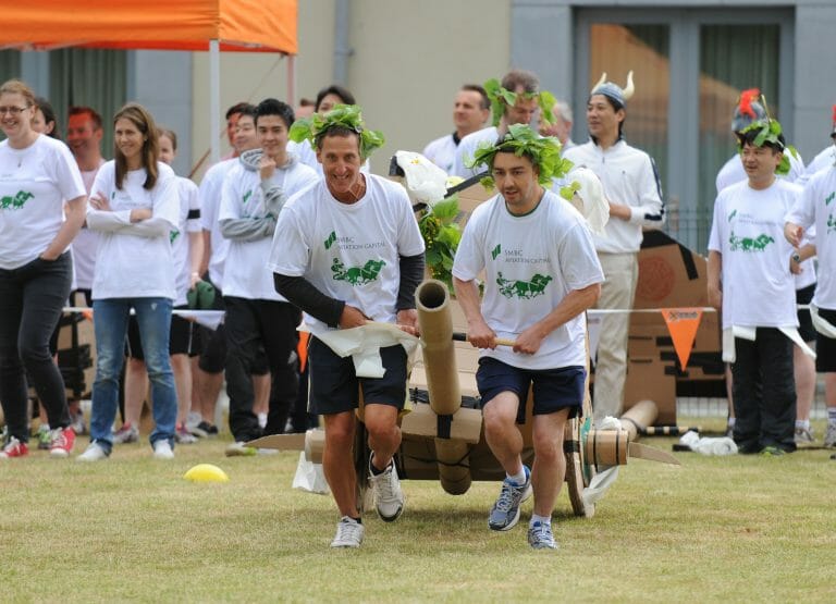 Delegates working together to pull their chariot they built, during the final race of Flat Out Chariots, a corporate game.