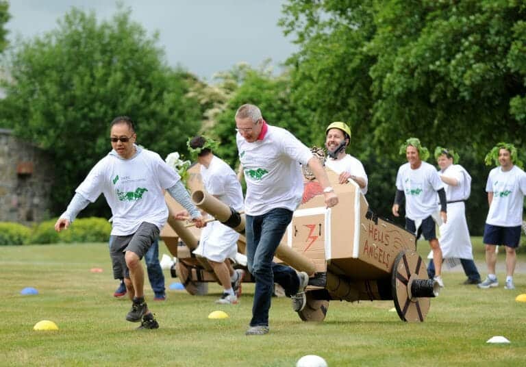 Delegates working together to pull their chariot they built, during the final race of Flat Out Chariots, a corporate game.