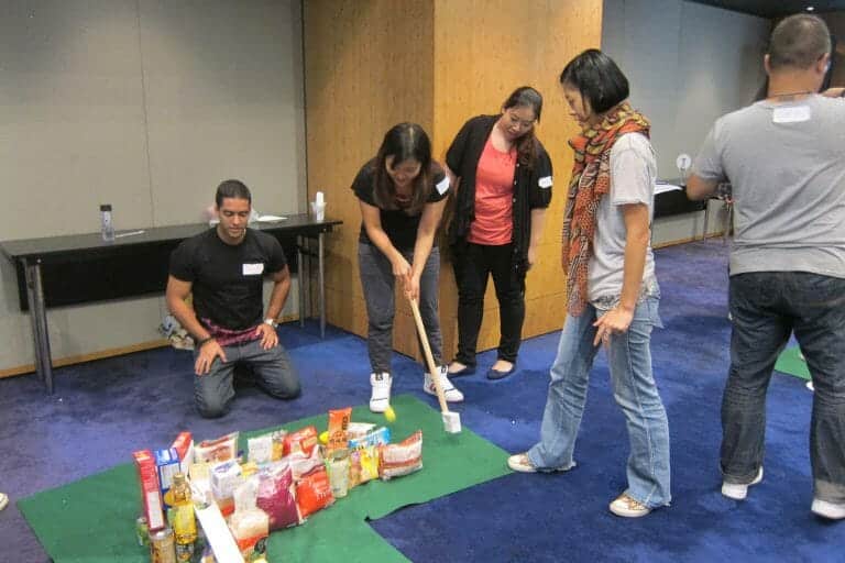 Delegates playing golf together on their sustainable pitch and putt course they built during their team building activity.