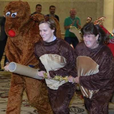 3 employees dressed as reindeers pulling Santa's sleigh during the christmas themed Team Building Game by Orangeworks.
