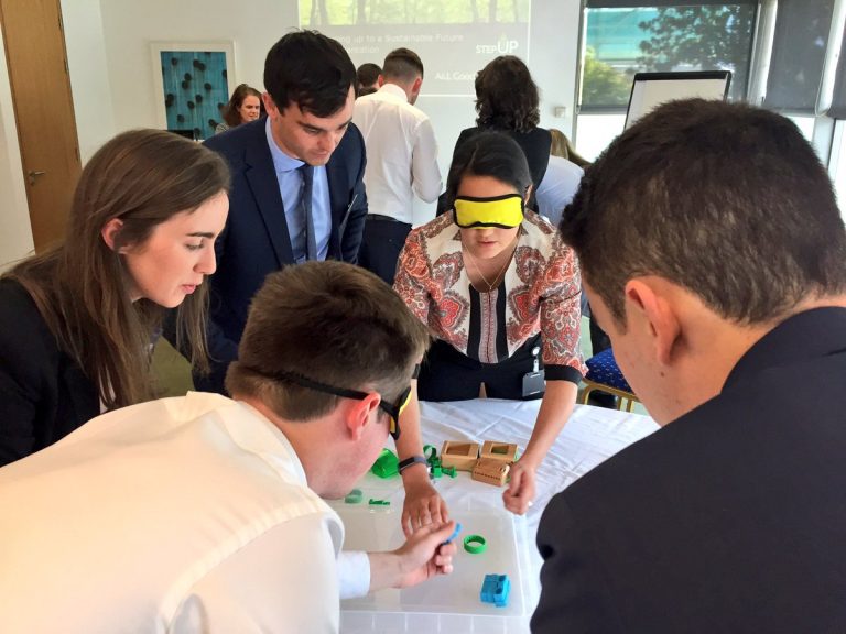 Blindfolded delegates putting together their cars during Need 4 Speed, a charity themed corporate team building game.