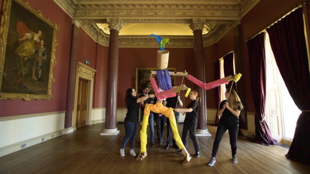 Delegates work together to move the giant puppet they created during a creative team-building experience by Orangeworks.