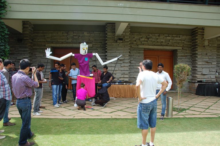Delegates work together to move the giant puppet they created during a creative team-building experience by Orangeworks.
