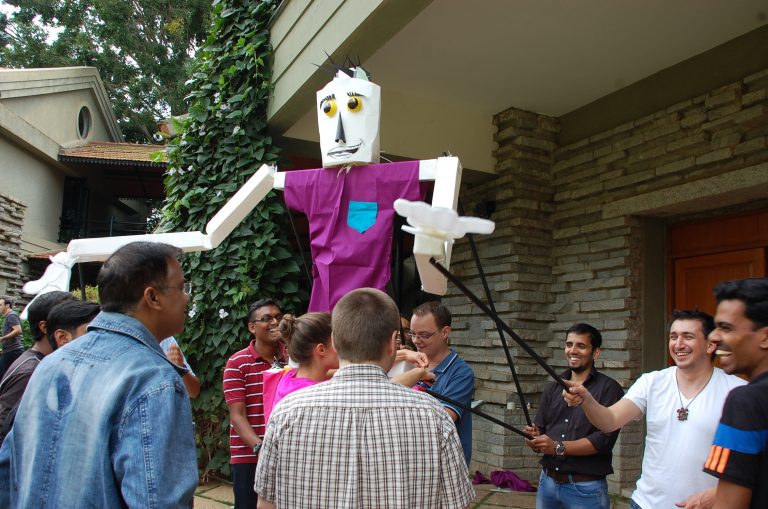 Delegates work together to move the giant puppet they created during a creative team-building experience by Orangeworks.