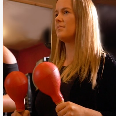 Participant of the corporate team building event Re-Percussion, shaking red maracas.