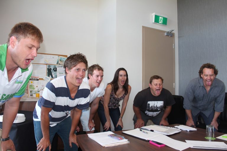 Delegates bending over with there tongues out as they learn some mindfulness and wellness techniques to practice.