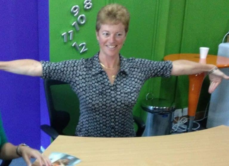Delegate stretching her arms during Head to Toe, a mindfulness team-building activity hosted by Orangeworks.