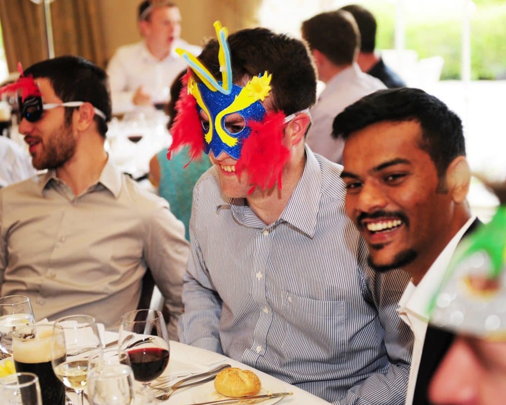 Happy delegates taking part in role play team building game