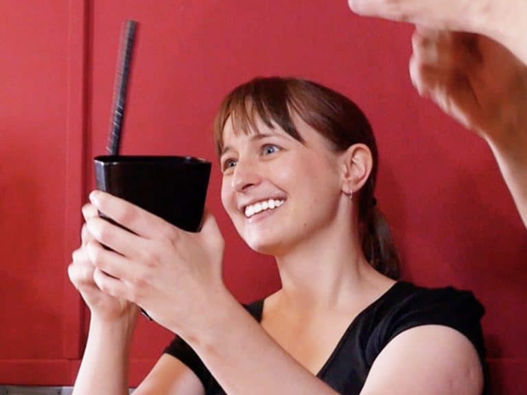 Delegate smiling with her instrument, listening for the instructor to give directions for the music team building event.