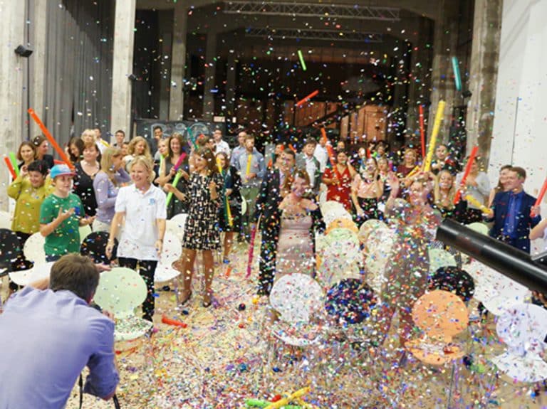 Confetti falling as the participants of Boom Time celebrate the finale of a conference energiser while playing music with their boom whackers.