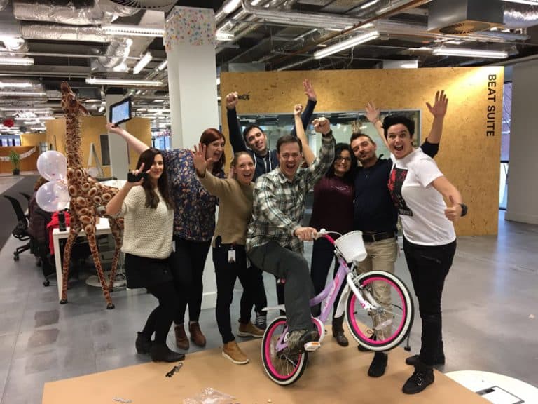 Delegates smile for a photo with the bike they have built for charity during Orangeworks team charity event Build a Bike.