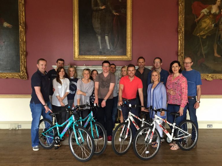 Group of delegates with the bikes they built during an Orangeworks team-building activity that gives back to the community.