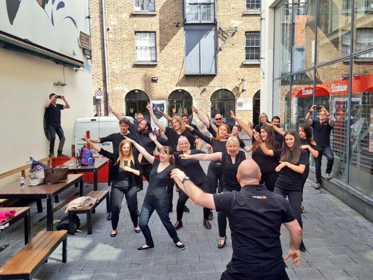 A Team posing all in black for the shooting of their commercial during their team building exercise hosted by Orangeworks.
