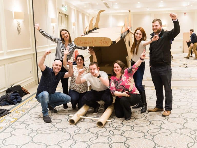 Team smiling with their rickshaw in Flat Out Rickshaw Racing, a team bonding challenge hosted by Orangeworks.