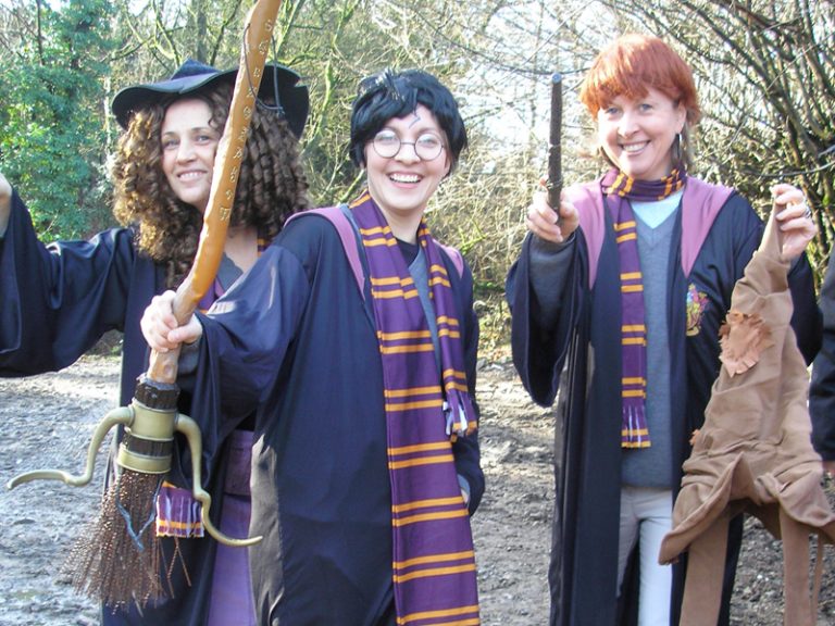 Delegates dressed as Harry, Ron and Hermione smiling for a group photo together during the team activity by Orangeworks.