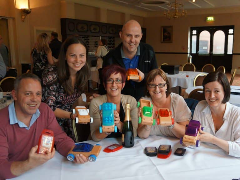 The winning team of Need 4 Speed, a charity based corporate activity, smile with their prize and their creations.