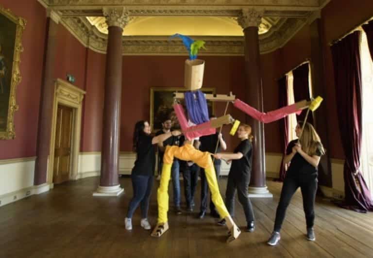 Delegates work together to move the giant puppet they created during a creative team-building experience by Orangeworks.