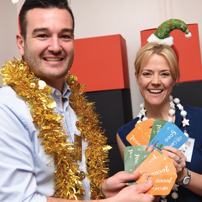 Delegates smiling with their playing cards during 12 Teams of Christmas, a Christmas themed team-building exercise.
