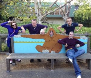 A group posing like monkeys at the Dublin Zoo during Orangeworks treasure hunt game.