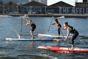 3 ladies paddle boarding duriung their team away day with surfdock watersports.