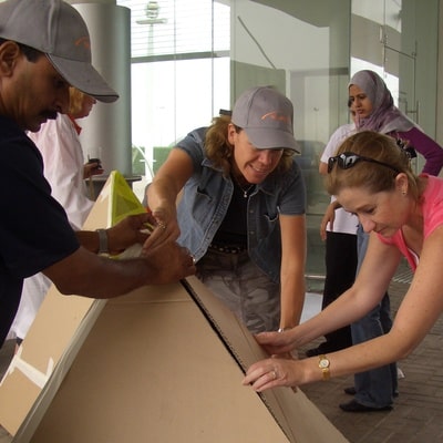 Delegates of flat out pyramids by orangeworks, working together to align the cardboard into pyramid shape.