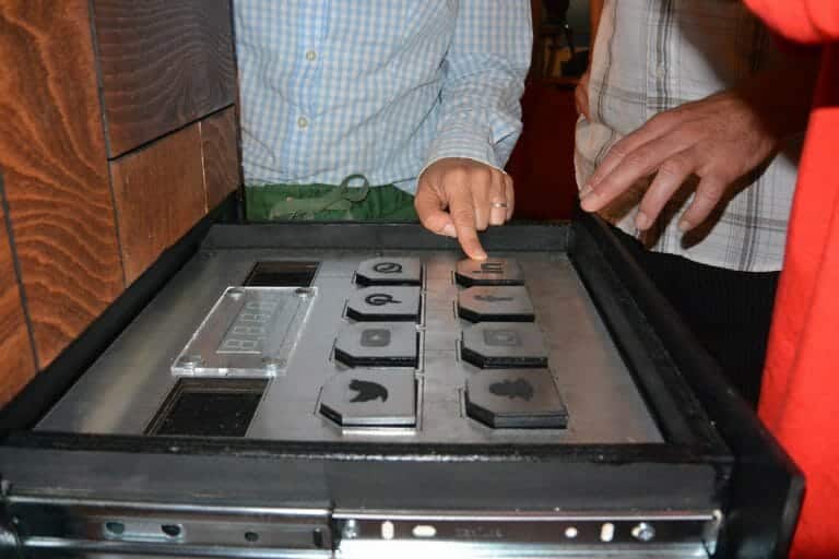 Two delegates playing Red Alert, the team challenge game. The game has social media logos and a delegate pressing a button.