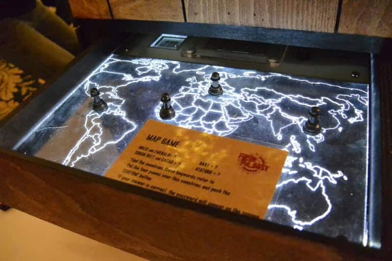 The red alert map game in a wooden box with lights going through it. Counters and instructions are placed on top.