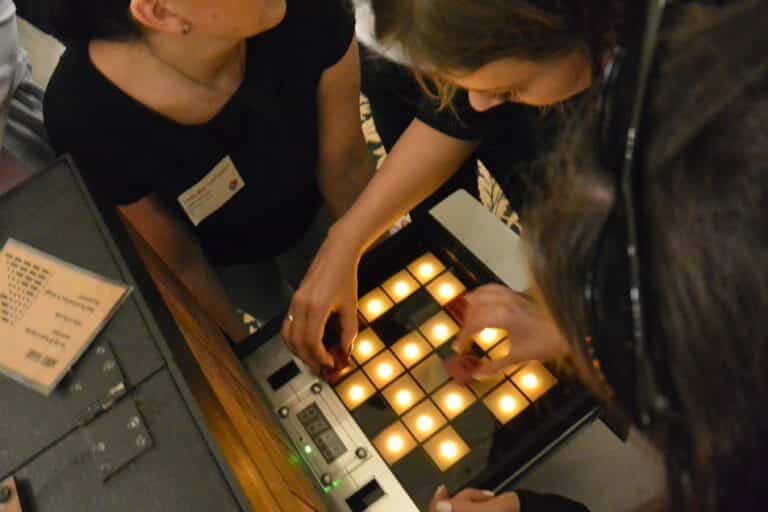 2 delegates playing red alert, the interactive team bonding challenge by Orangeworks. They are placing red covers on lights.