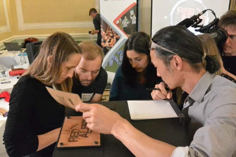 A group of delegates playing Red Alert, the interactive team building game by Orangeworks. Delegates are solving puzzles