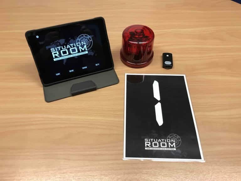 situation room iPad on a table with a light and a sign on the table also.