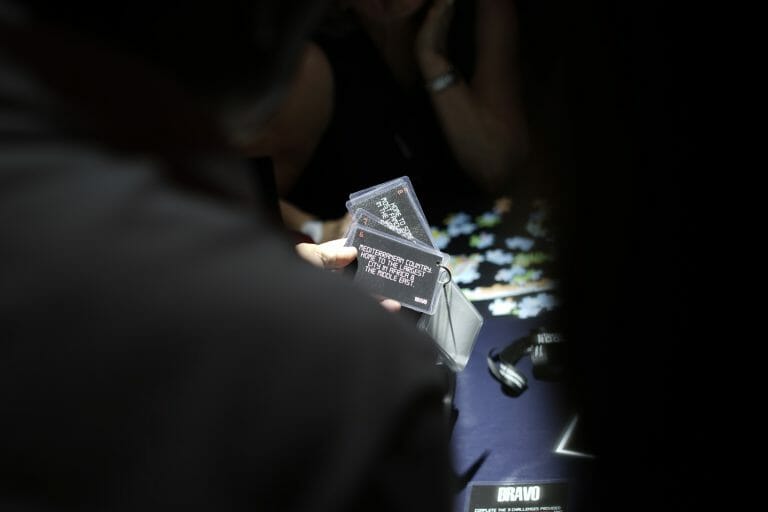 a zoomed in photo of someone holding cards in the situation room. A few things on the table in the background.