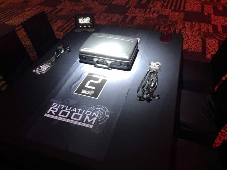 The teambuilding game Situation Room laid out on a table including a briefcase and lanyards.