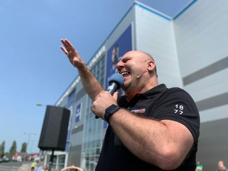 Ed Freitas, Orangeworks haka instructor speaking to a crowd.