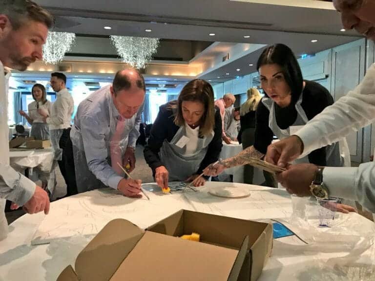 Delegates of The Big Picture team building game painting their team canvas.