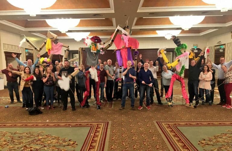 Delegates holding up the giant puppets they created during their teambuilding day with Orangeworks.