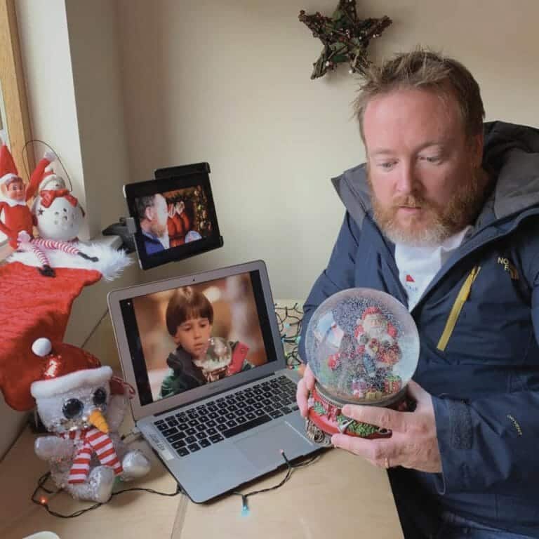 Delegate looking at a snowglobe as he plays Orangeworks virtual work Christmas party game called A Picture Perfect Christmas