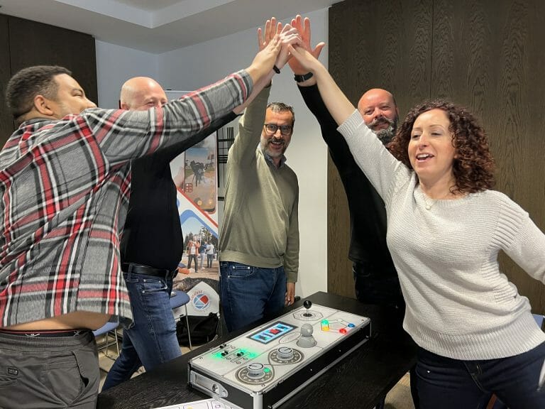 A group of delegates high-fiving after completing Synergyk - one of Orangeworks team building activities.