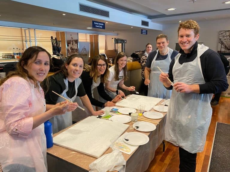 Delegates of The Big Picture team building game painting their team canvas.