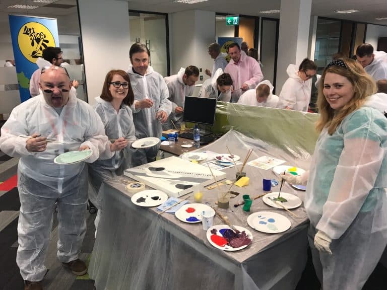 Delegates of The Big Picture team building game painting their team canvas.