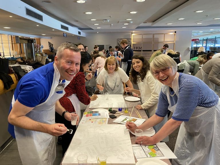 Delegates of The Big Picture team building game painting their team canvas.