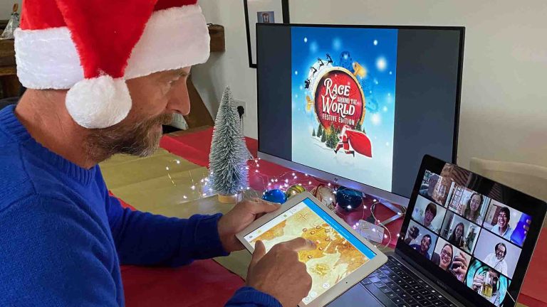 Delegate of Orangeworks remote team building activity Race Around the World Festive wearing a Santa hat and chatting with her team mates on Zoom.