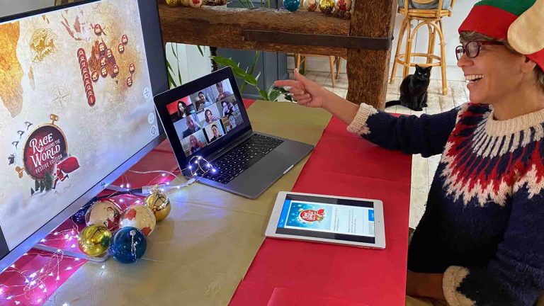 Delegate of Orangeworks remote team building activity Race Around the World Festive wearing a Santa hat and chatting with her team mates on Zoom.