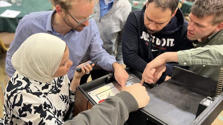 Delegates pointing at one of the Red Alert boxes - one of Orangeworks experiential activities.