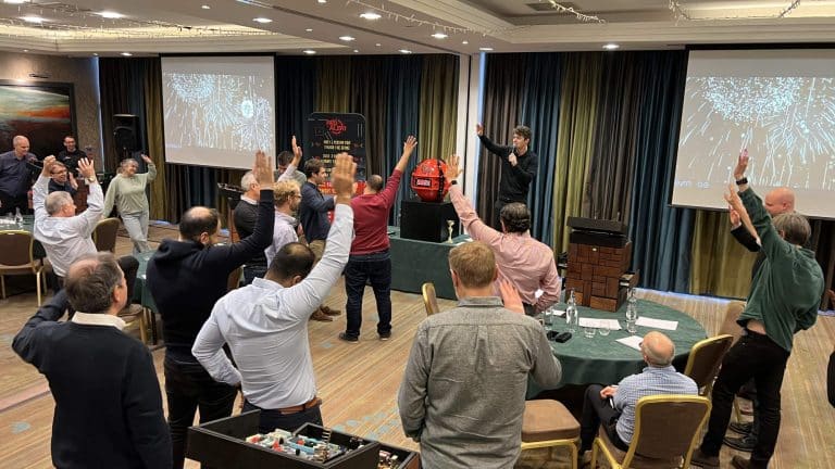 Delegates raising their hands during Orangeworks experiential activity called Red Alert.