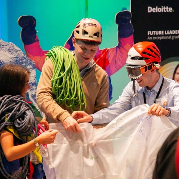 Delegates putting on costume mountain climbing gear as part of Peak Performance, one of Orangeworks Team Development Activities.