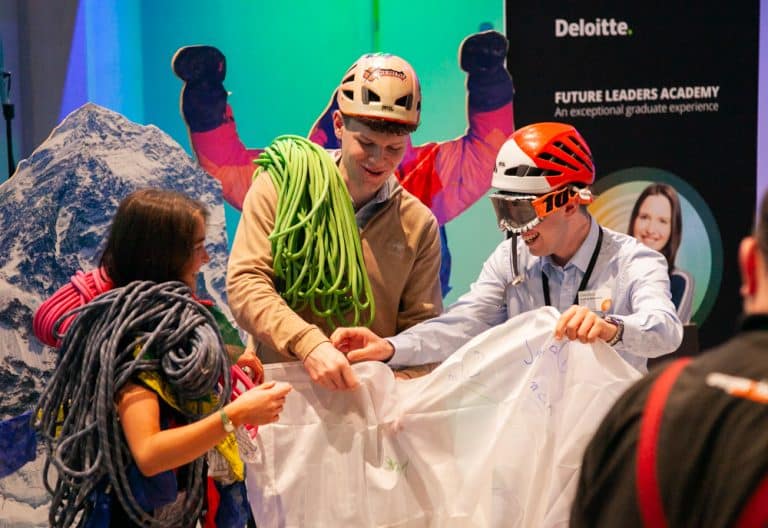 Delegates putting on costume mountain climbing gear as part of Peak Performance, one of Orangeworks Team Development Activities.