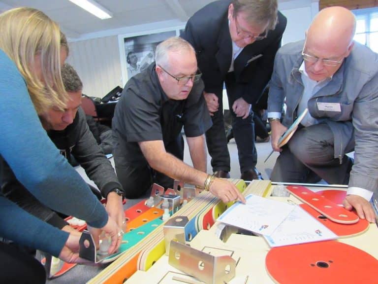 Delegates working together building their chain reaction contraption as part of their team building workshop with Orangeworks.