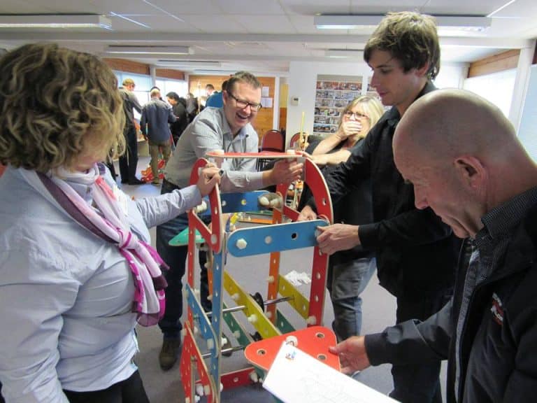 Delegates working together building their chain reaction contraption as part of their team development workshop with Orangeworks.