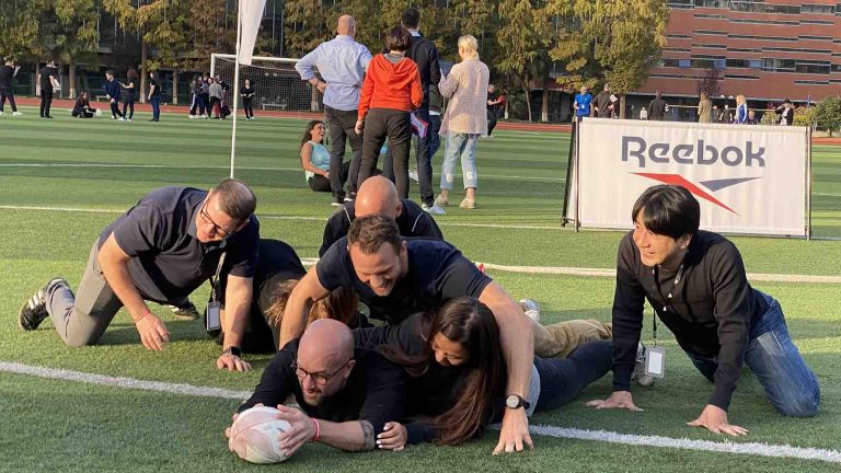 Delegates of Orangeworks outdoor team building activity Quickfire Olympics playing rugby together.