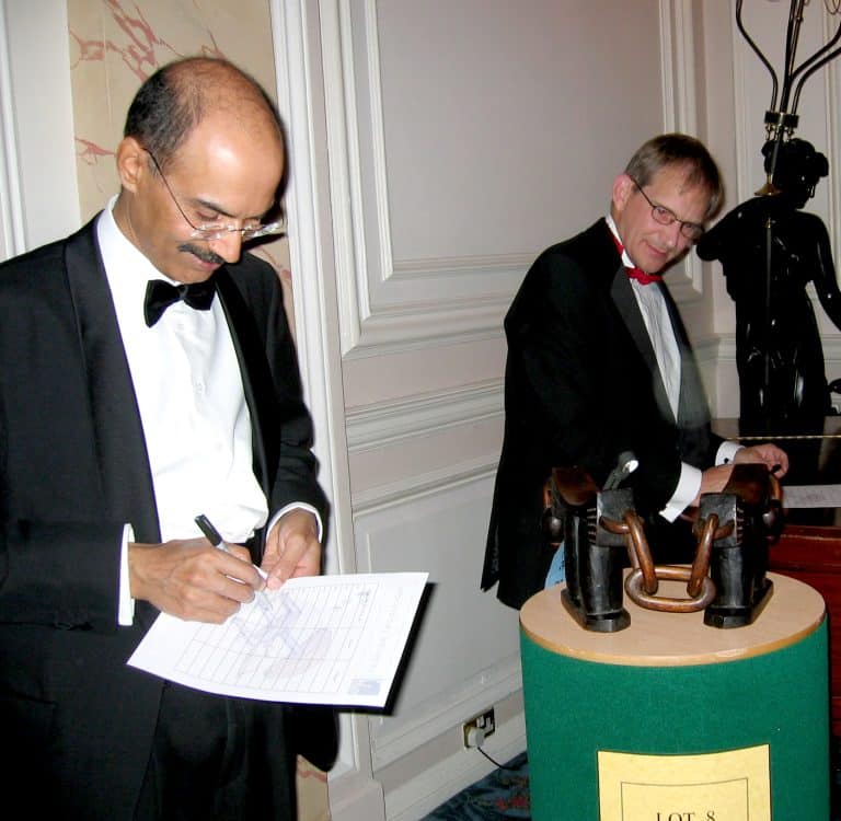 Two delegates looking at and taking notes on one of the antiques used as part of Orangeworks team building activity called The Curio Show.